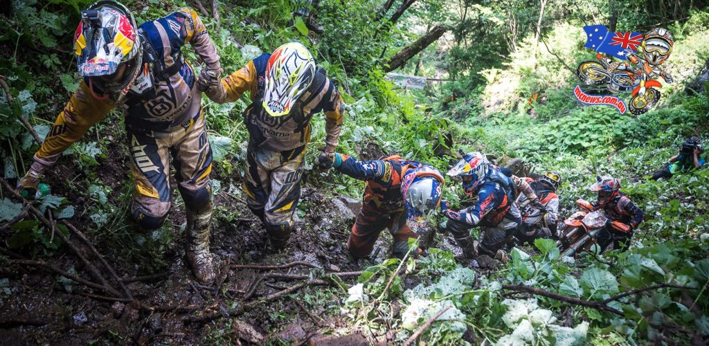 Riders help each other drag their machines up a slope that proved urideable