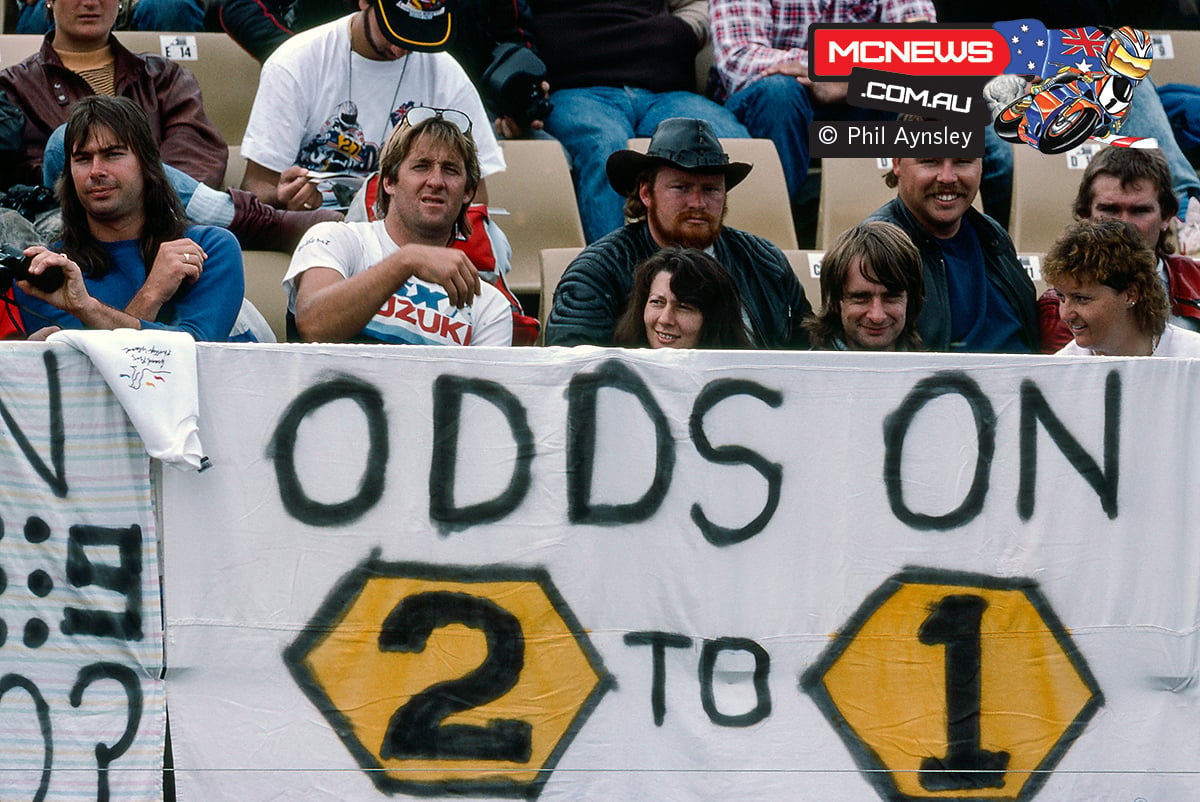 Spectators behind a handmade Odds On 2 To 1 banner at the 1989 Australian Motorcycle Grand Prix