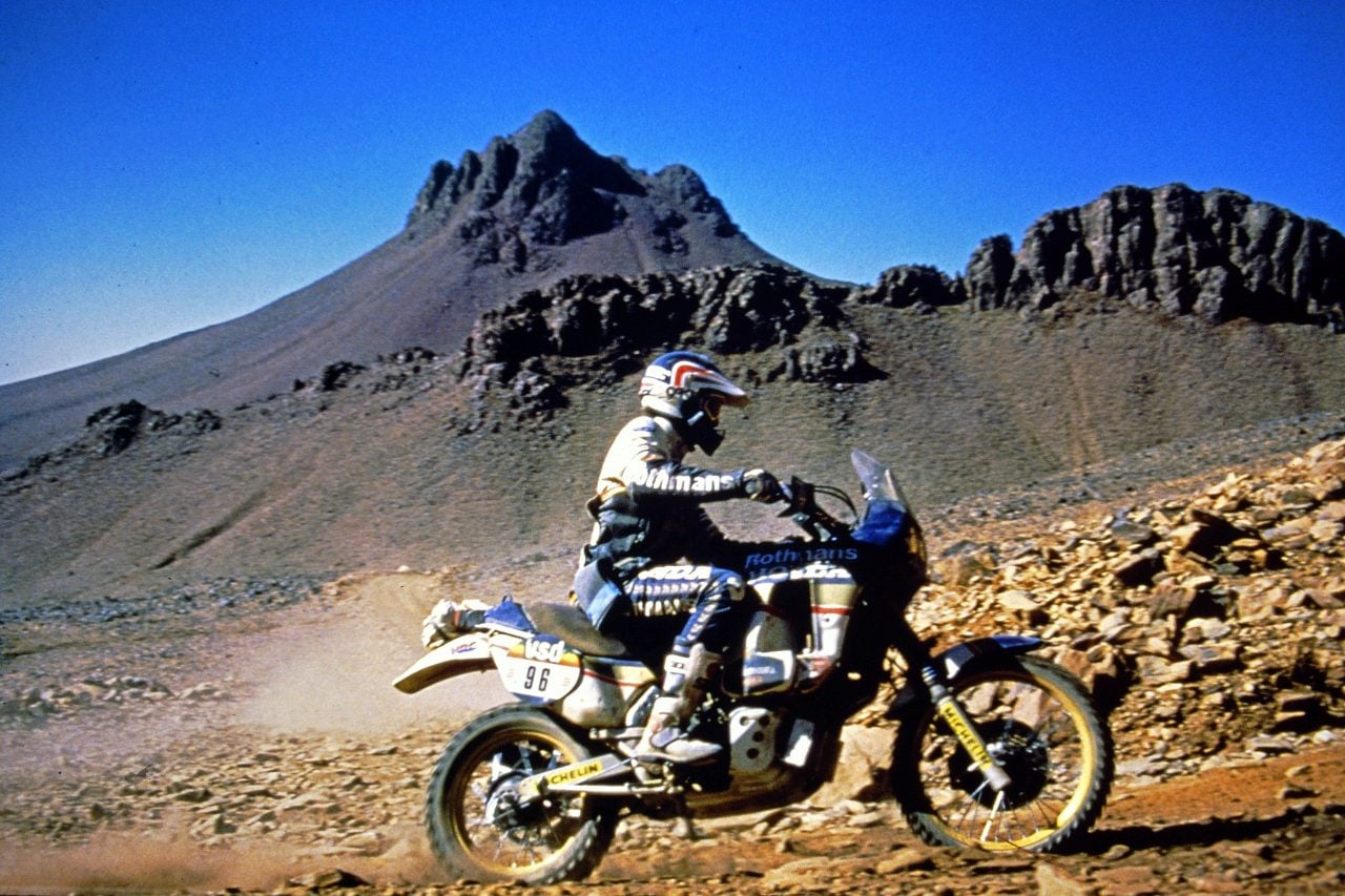 Cyril Neveu rides a Rothmans Honda NXR750 along a rocky track during the 1986 Dakar.