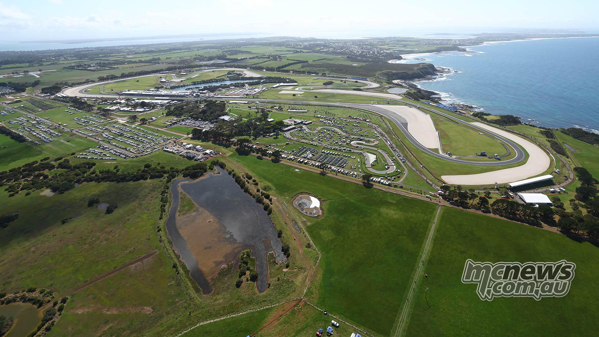 Aerial view of Phillip Island Grand Prix Circuit, its sweeping layout, spectator areas and the Bass Strait coastline
