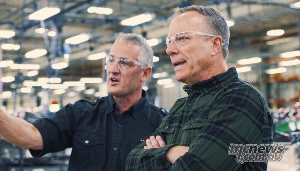 Indian Motorcycle CEO Mike Kennedy wearing safety glasses beside another man on a factory floor