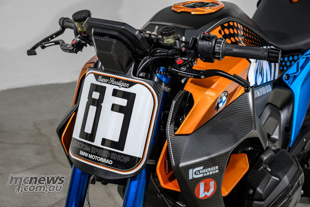 Close-up of BMW R 1300 R Superhooligan number board showing start number 83 tribute detail.