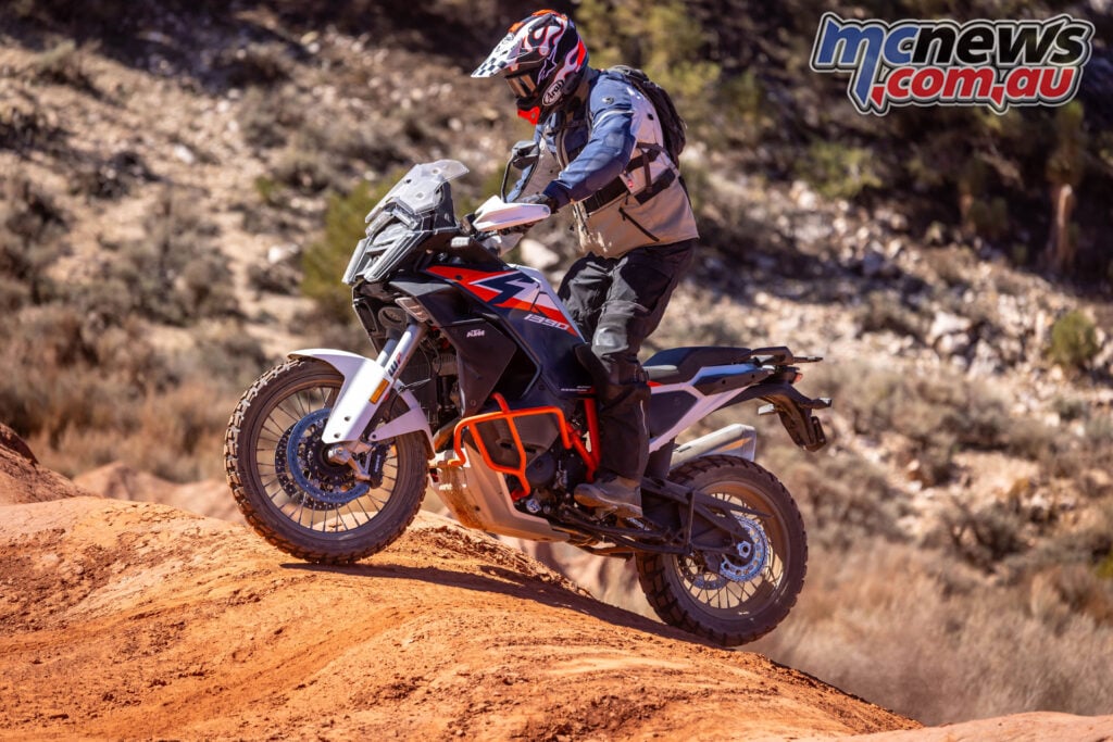 2026 KTM 1390 Super Adventure R ascending a red dirt trail in desert terrain