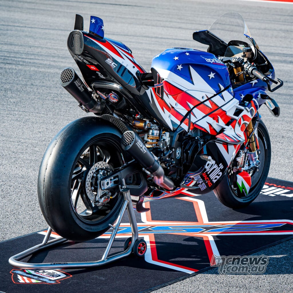 Rear three-quarter view of the Aprilia X 250TH on stands showing the exhaust system, slick rear tyre and race tail.