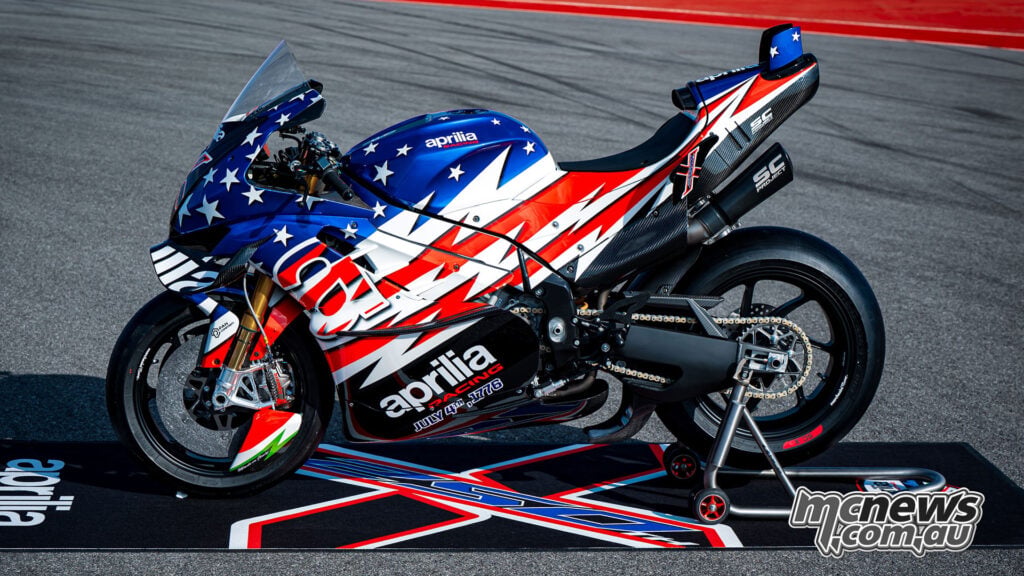 Full side profile of the Aprilia X 250TH on paddock stands showing the stars-and-stripes livery and RSV4-based silhouette.