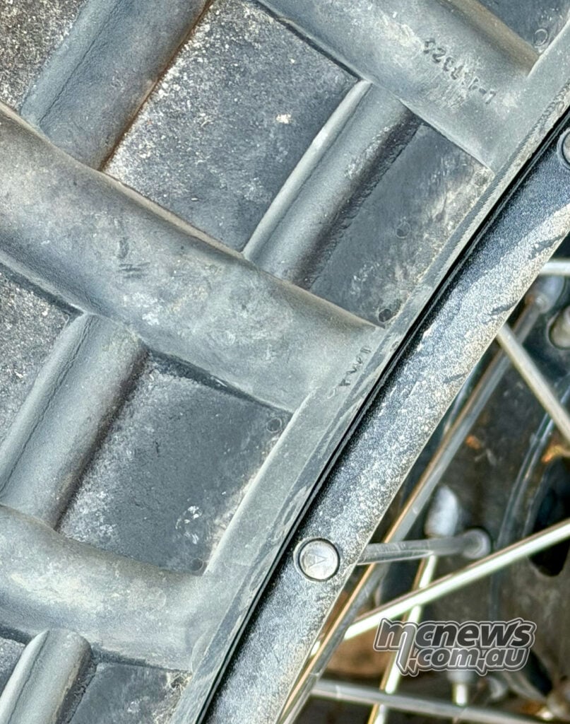 Close-up of a dusty Continental TKC 80² tread on a spoked wheel rim after off-road use.