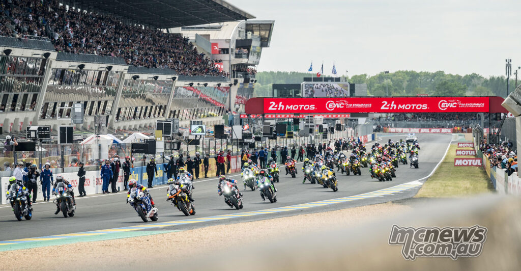 Large field of motorcycles starts the 24 Heures Motos at Le Mans in front of packed grandstands.