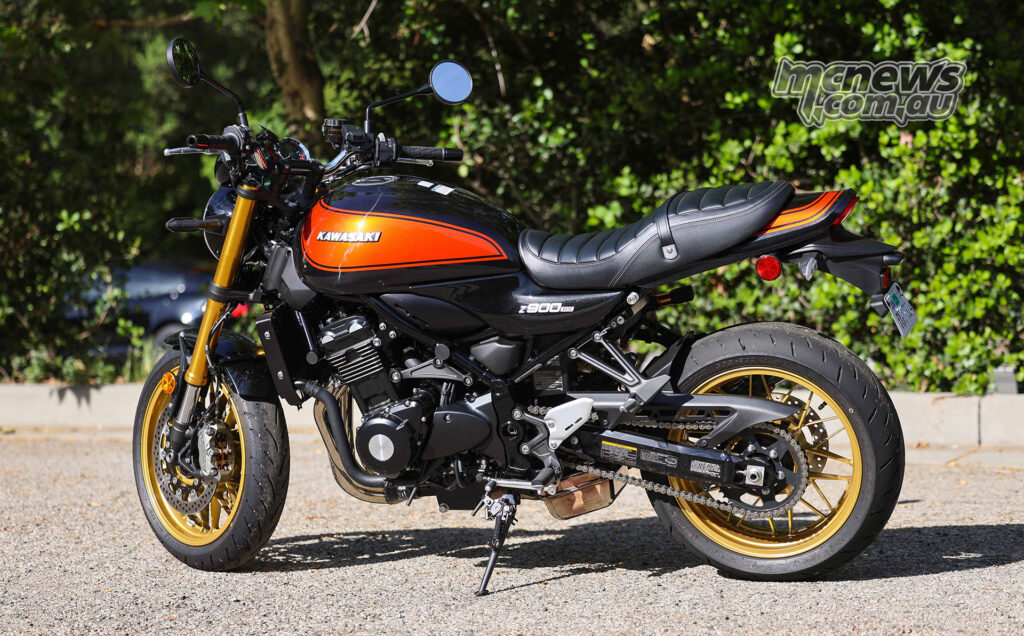 Rear three-quarter view of 2026 Kawasaki Z900RS SE showing chrome exhaust and gold rear wheel