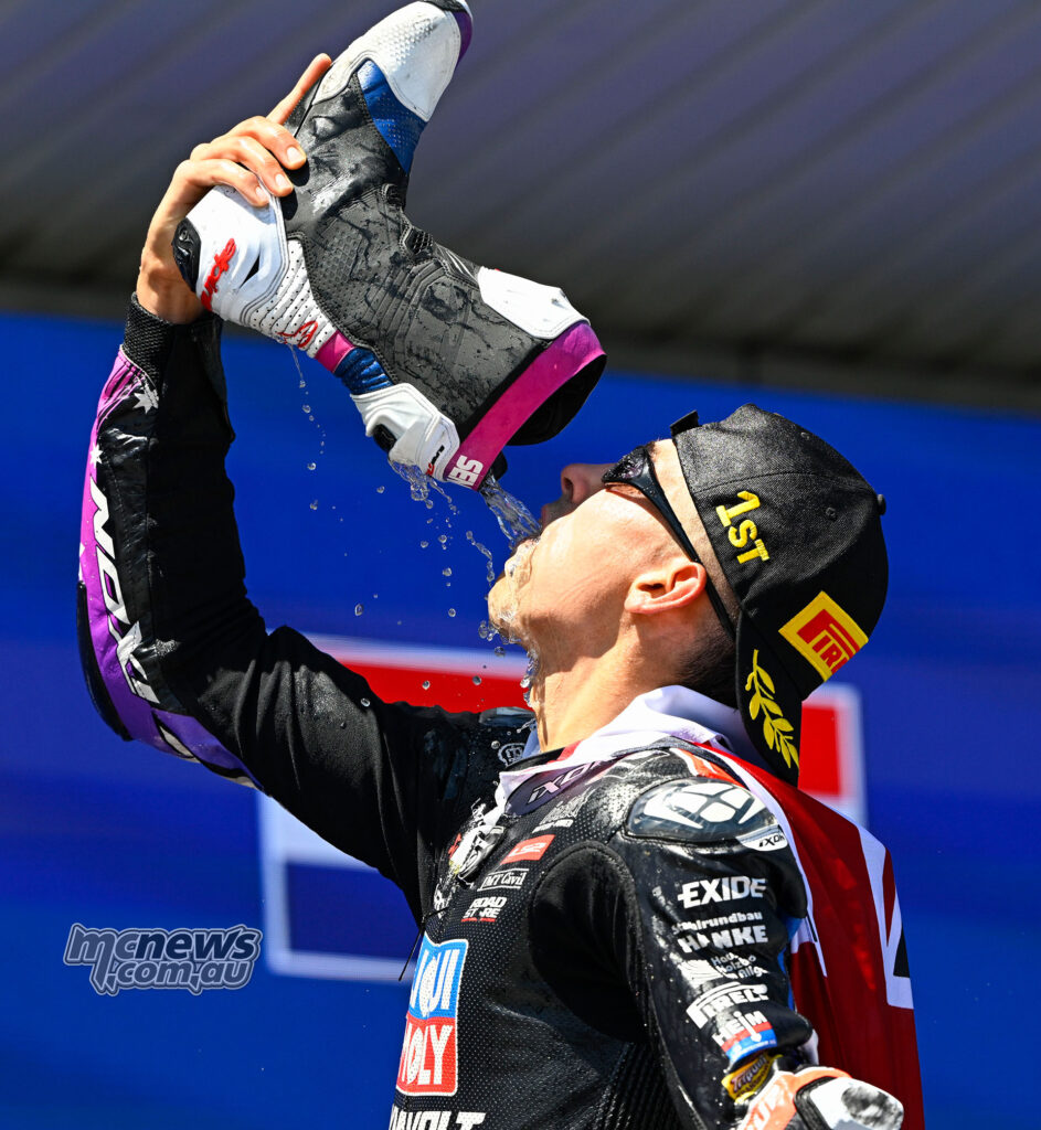 Senna Agius drinks from his boot on the Moto2 podium at Jerez.