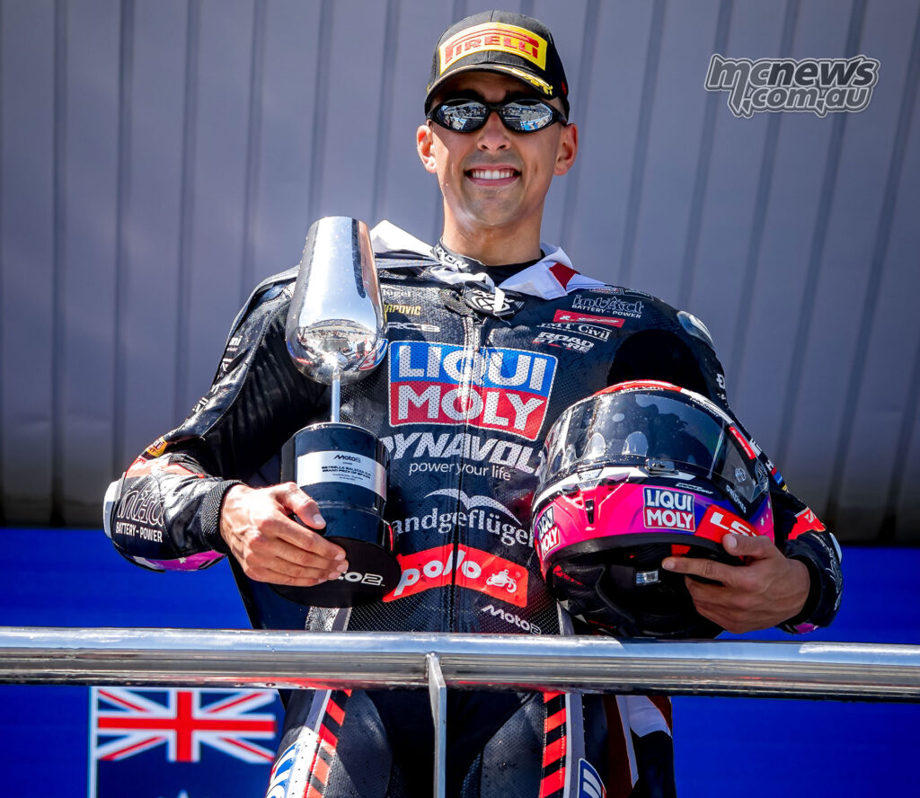 Senna Agius holds the Moto2 winner’s trophy on the podium at Jerez.