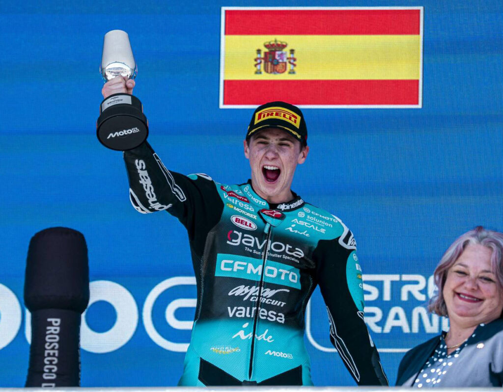 Máximo Quiles celebrates on the Jerez Moto3 podium with the winner’s trophy.