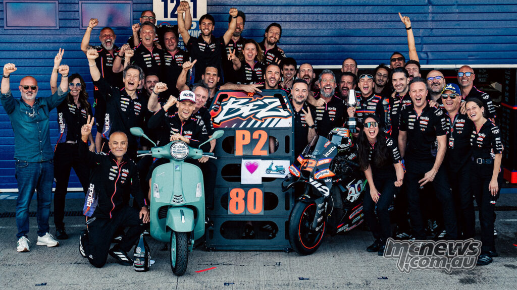 Marco Bezzecchi and the Aprilia Racing team pose together in pit lane after finishing second at Jerez.
