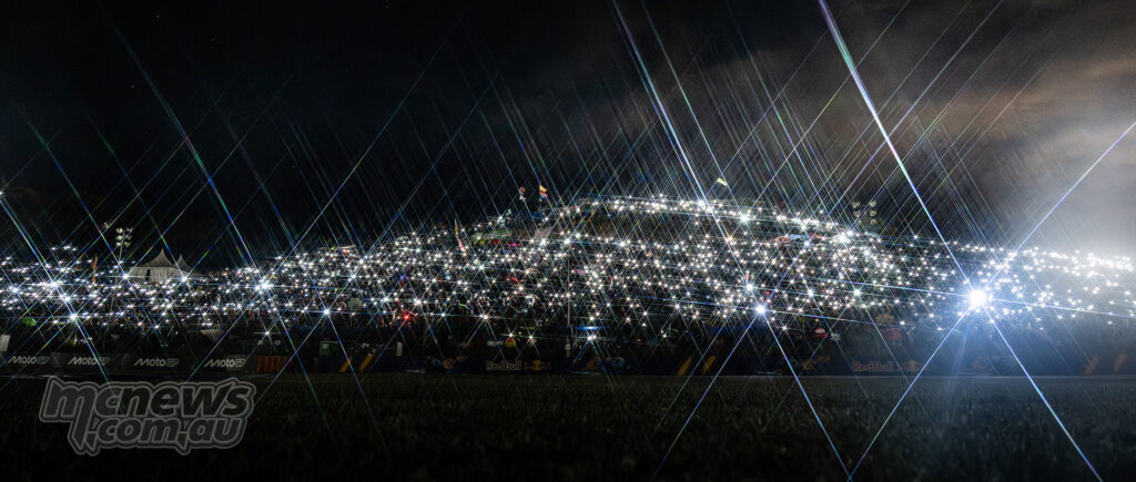 A huge hillside crowd at Jerez is illuminated by thousands of phone lights before dawn.