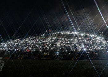 A huge hillside crowd at Jerez is illuminated by thousands of phone lights before dawn.