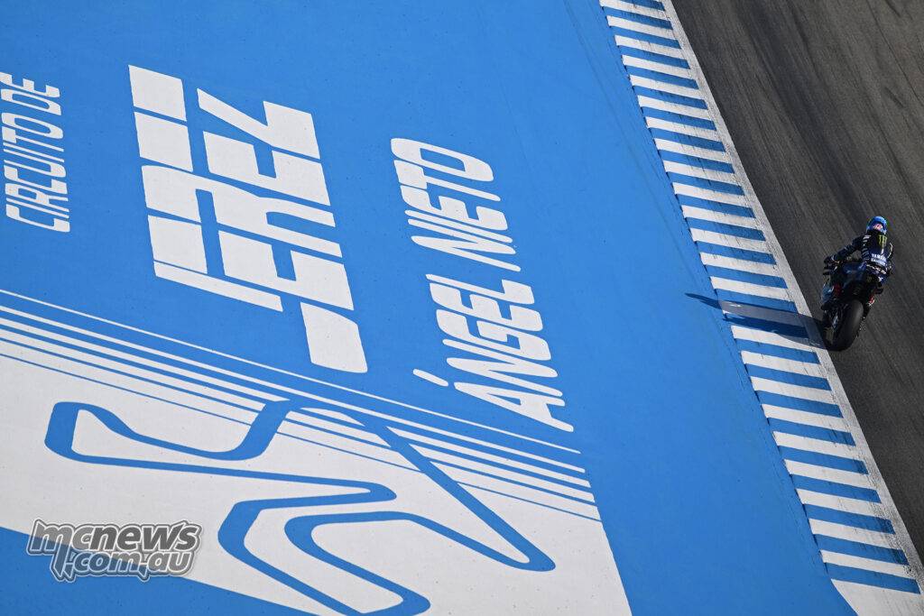 Distant view of Álex Rins riding the Yamaha past the large blue Jerez circuit signage.