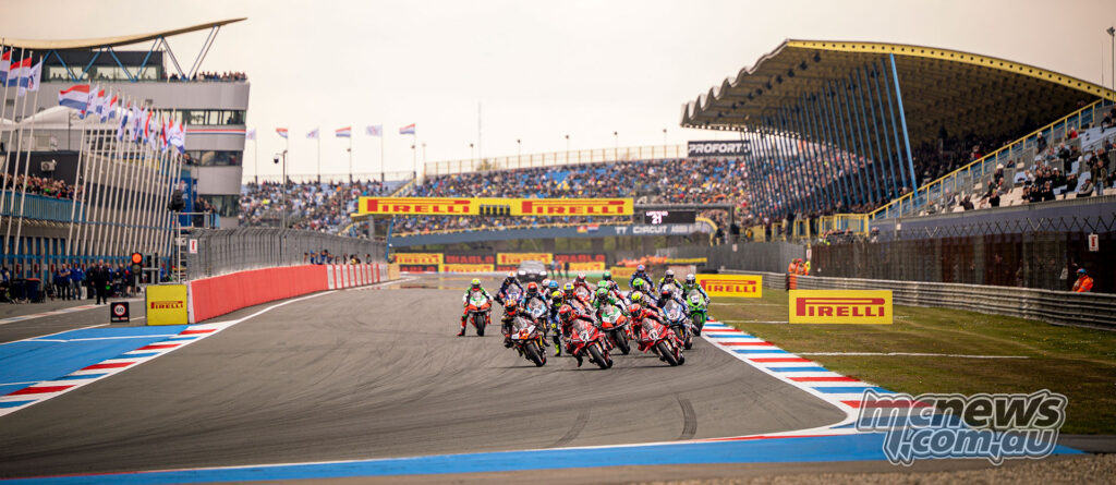 Wide shot of the WorldSBK field accelerating away from the grid at the start of Race 1 at TT Circuit Assen.
