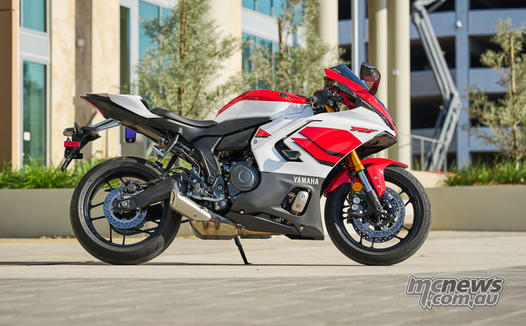 Full side profile of white and red 2026 Yamaha YZF-R7 parked outdoors.