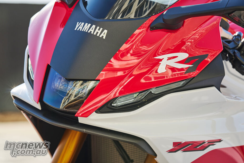 Close-up of red and white 2026 Yamaha YZF-R7 front fairing, headlight and mirror indicator.