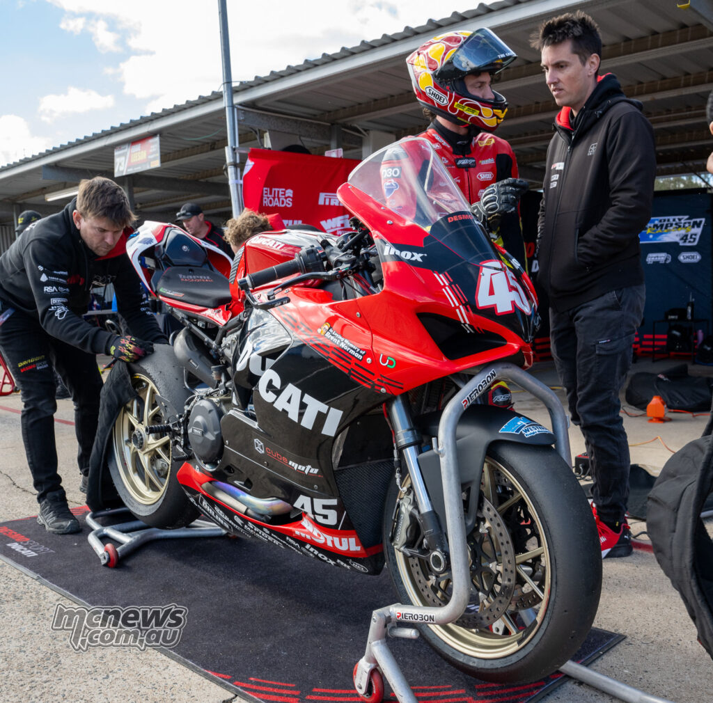 Olly Simpson stands beside the number 45 DesmoSport Ducati V2 in the Morgan Park pit lane during Next Gen Supersport qualifying.