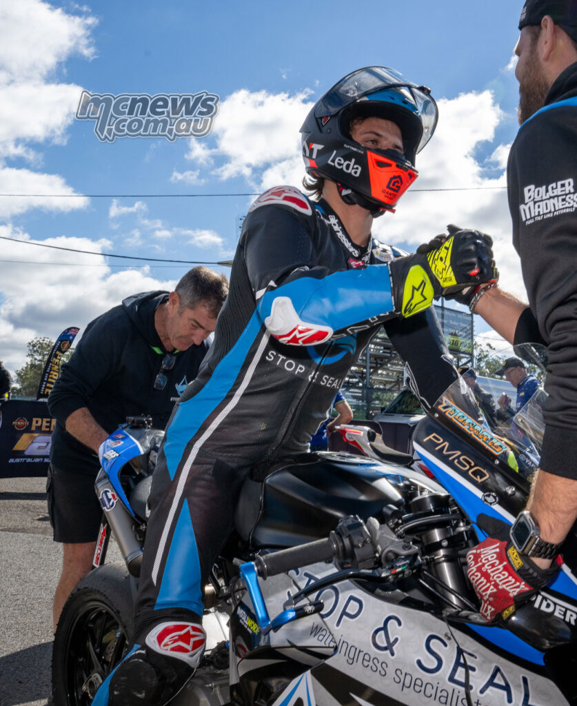 Tom Toparis receives a fist bump beside his Stop and Seal Ducati V2 after ASBK Next Gen qualifying at Morgan Park.