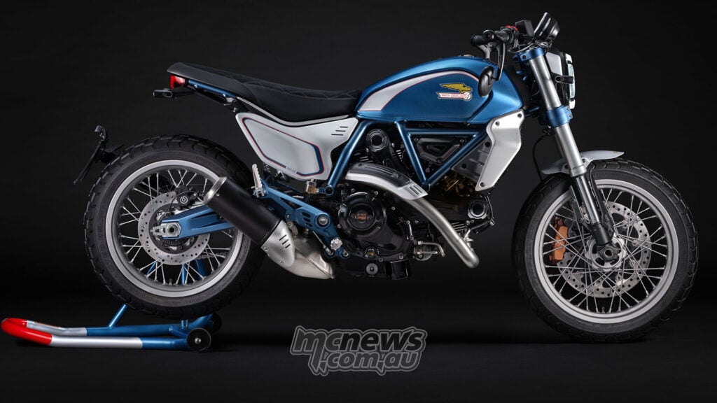 Ducati Scrambler 100 Collection special in metallic blue and white livery, shown in full side profile on a black studio background.