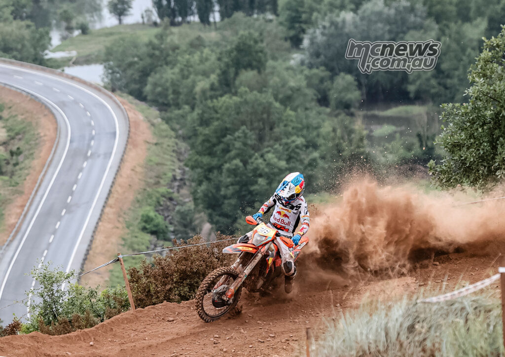 Josep Garcia slides his KTM through a dusty EnduroGP test section above a public road in Oliana, Spain.