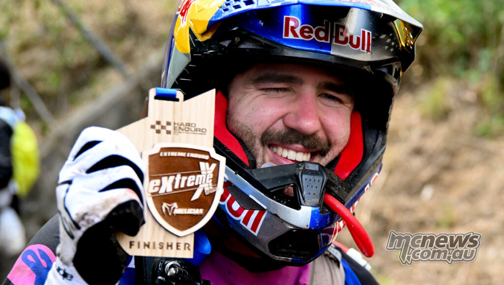 Manuel Lettenbichler smiles while holding his Extreme XL Lagares finisher trophy.