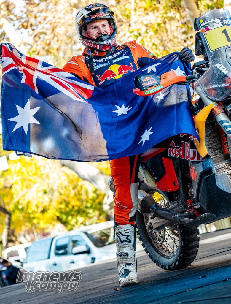 Daniel Sanders holds an Australian flag beside his Red Bull KTM rally bike after winning the 2026 Desafío Ruta 40.