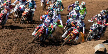 MXGP riders bunch tightly through the opening turns, with a Honda, KTM and Husqvarna among the lead bikes.