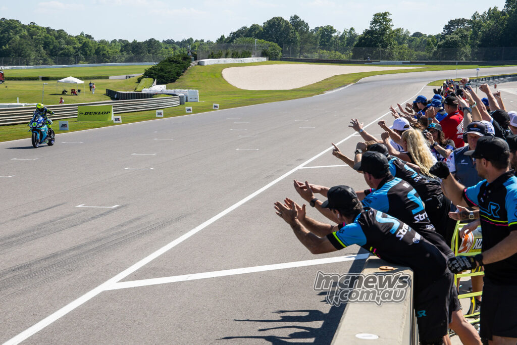 Mathew Scholtz crosses the line to win MotoAmerica Superbike race two at Barber as his team celebrates.