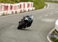 Rear view of Michael Dunlop leaning the Paton S1-R-650 through a bend at the Isle of Man TT.