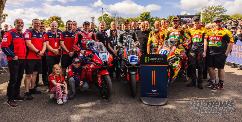 Michael Dunlop, Dean Harrison and Peter Hickman pose with their teams after finishing on the 2026 Supersport TT Race 1 podium.