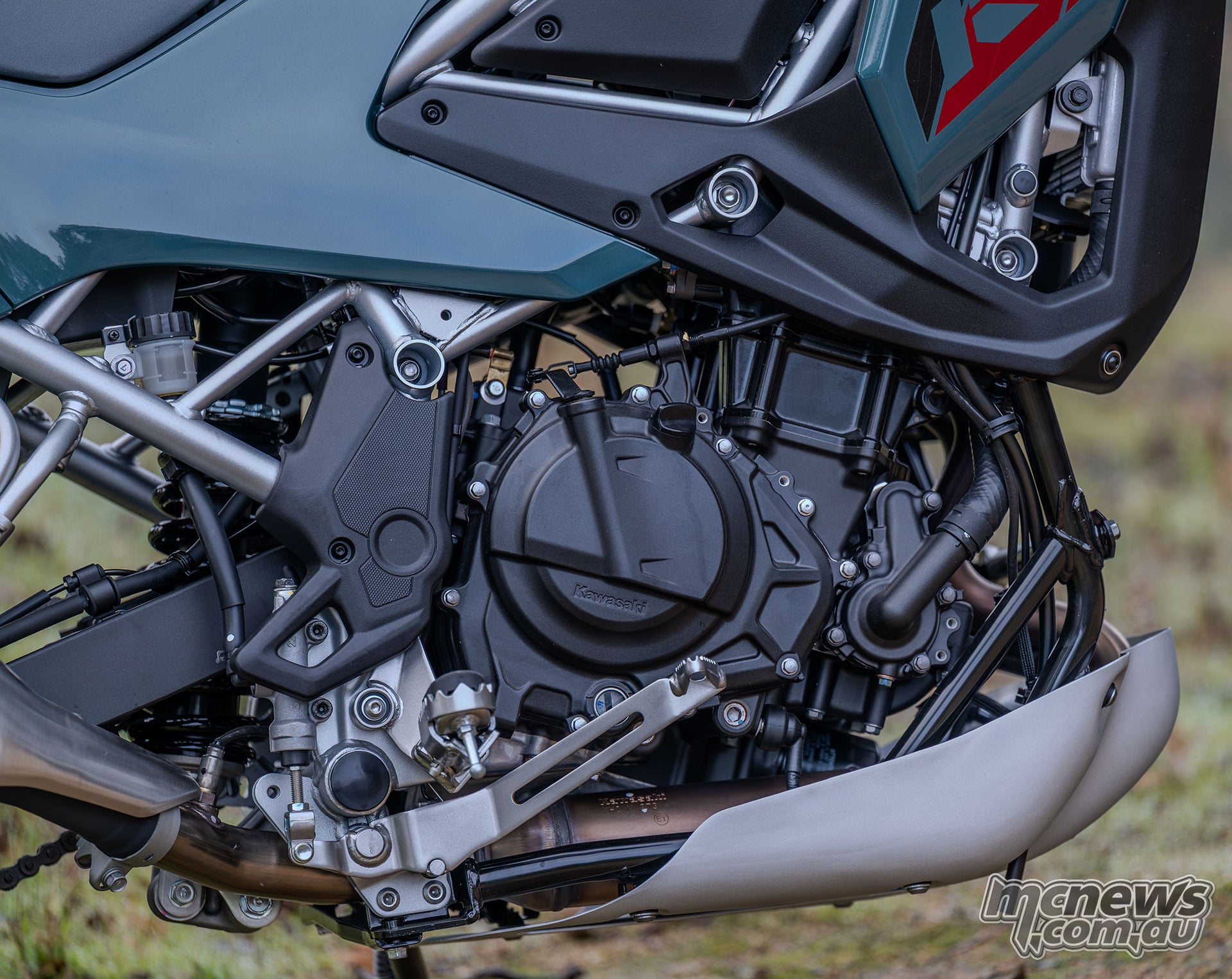 Close-up of the Kawasaki KLE500 SE engine, frame tubes, right footpeg and aluminium skid plate.