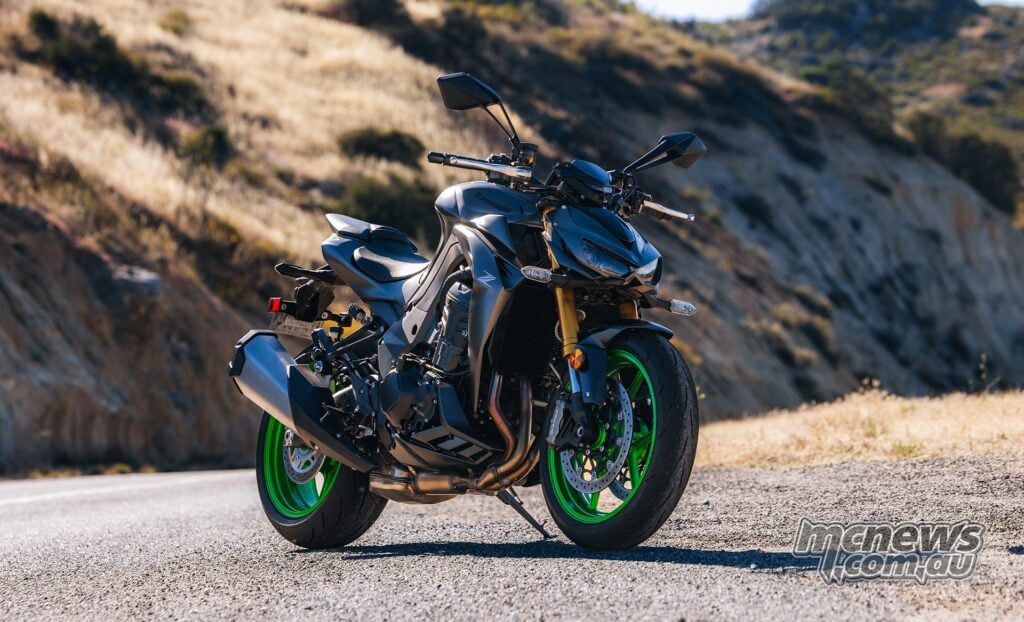 2026 Kawasaki Z1100 SE ABS parked on a mountain road, showing its grey bodywork, green wheels and aggressive nakedbike stance.
