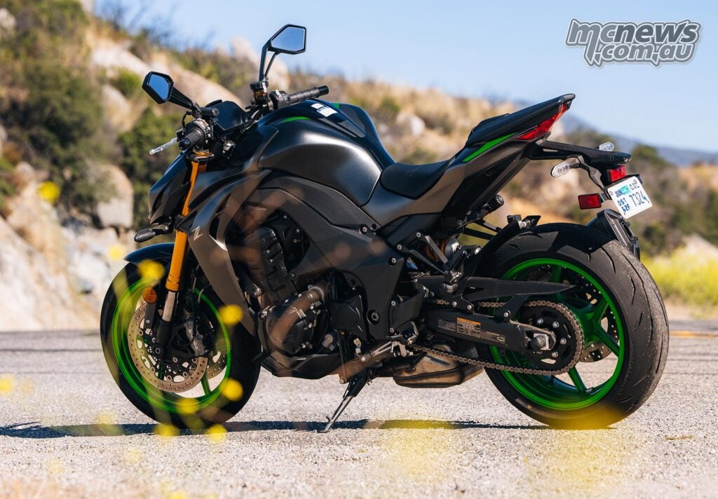 Rear three-quarter view of the Kawasaki Z1100 SE ABS parked on a roadside with green wheels and angular tail section.