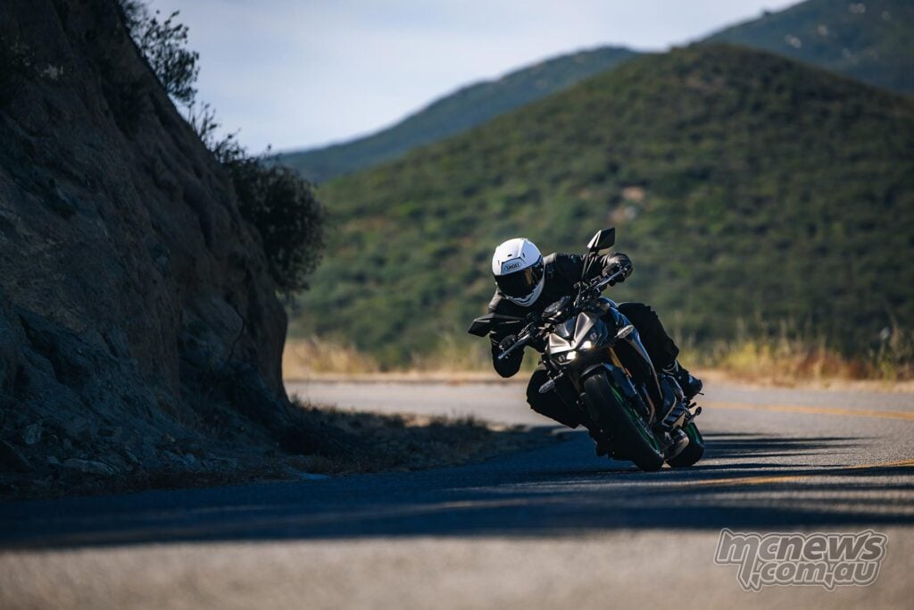 Rider leaning the Kawasaki Z1100 SE ABS through a shaded bend on a mountain road.