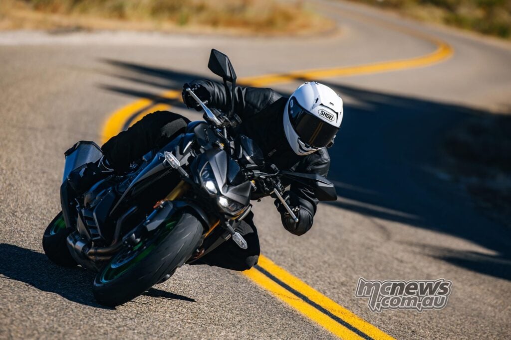 Overhead-style action shot of a Kawasaki Z1100 SE ABS leaned over on a winding road.