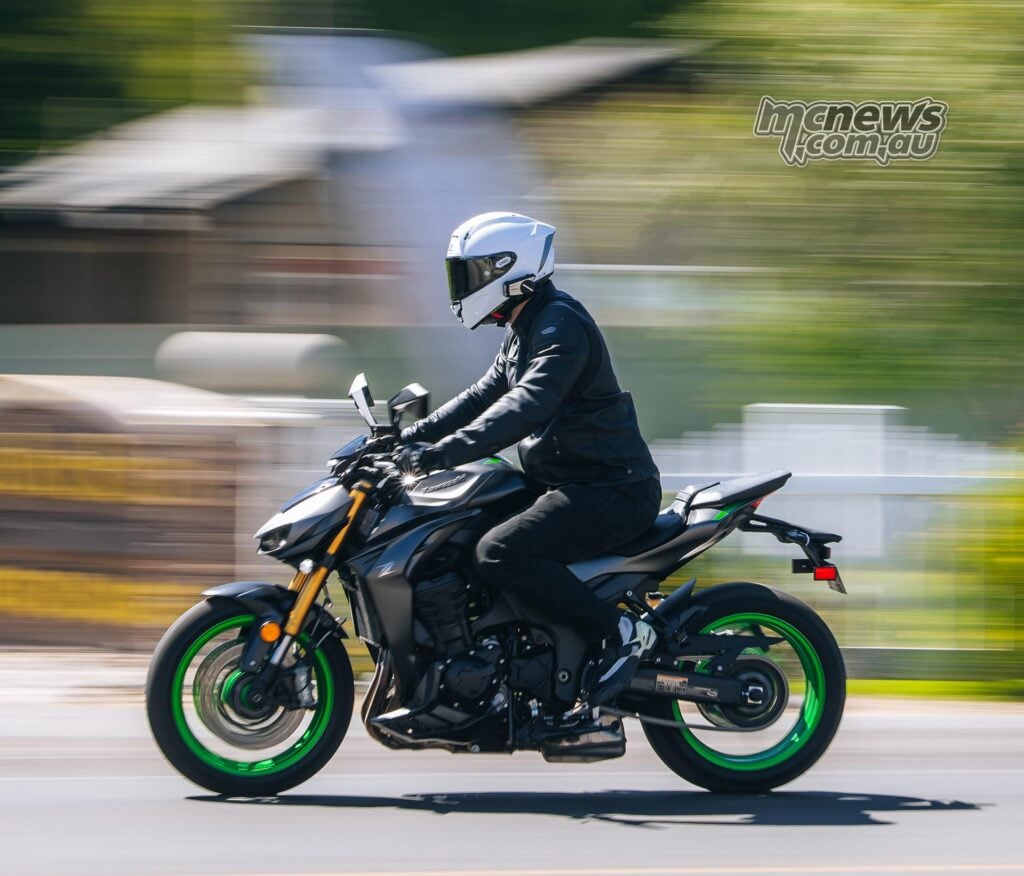 Side panning shot of a rider on the Kawasaki Z1100 SE ABS travelling along an urban road.
