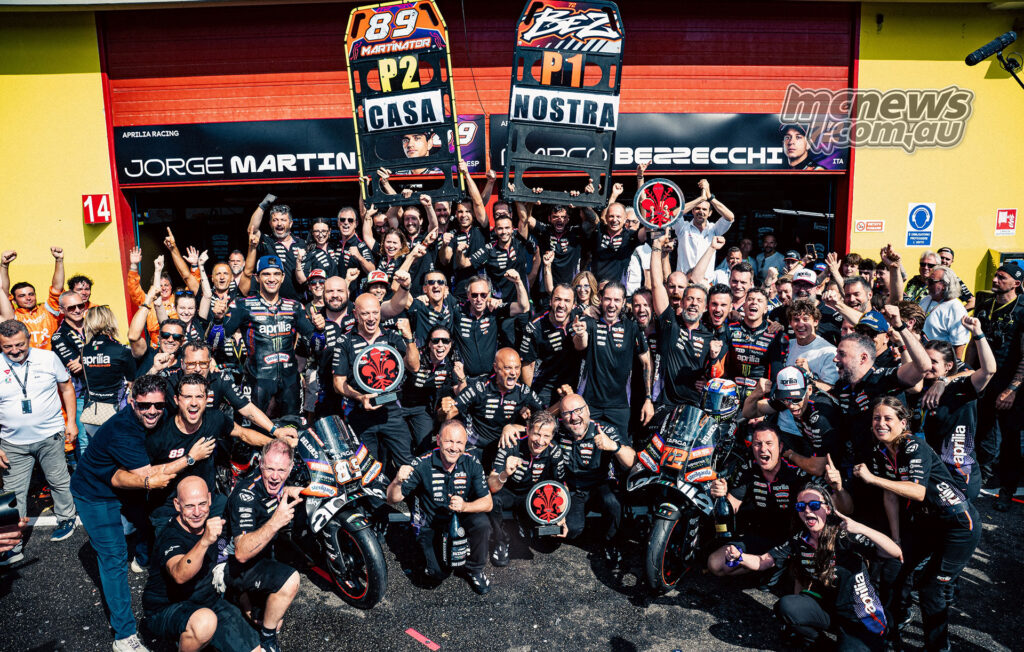 Aprilia Racing team celebrates outside the Mugello garage with Bezzecchi and Martin pit boards.