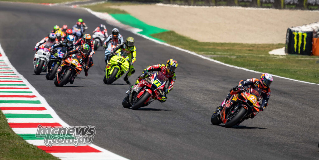 Enea Bastianini leads Diogo Moreira and a MotoGP pack through a Mugello corner.