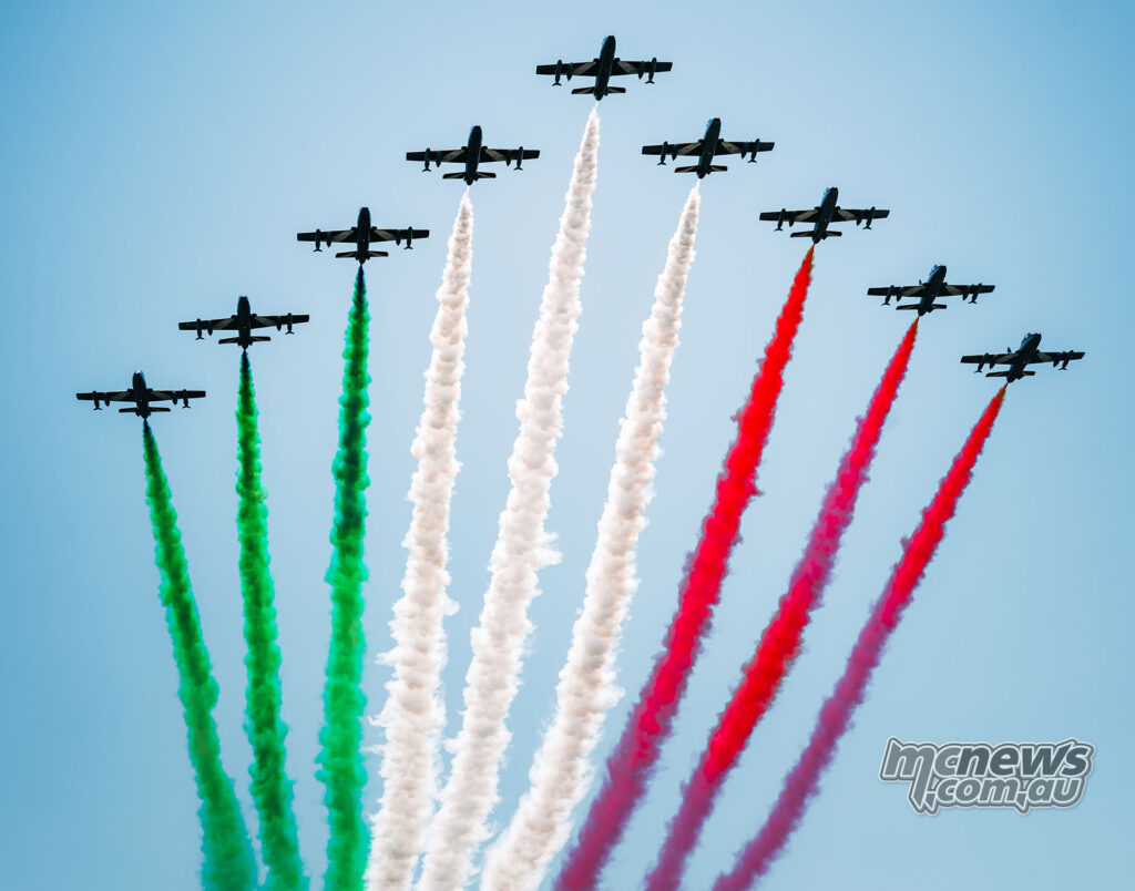 Italian aerobatic jets fly overhead with green, white and red smoke trails.