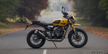 Yellow Triumph Scrambler 400 XC side profile showing spoked wheels, engine and exhaust.