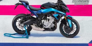 Full side profile of the 2026 CFMOTO 675NK GP Champion Blue on a race-themed display surface.