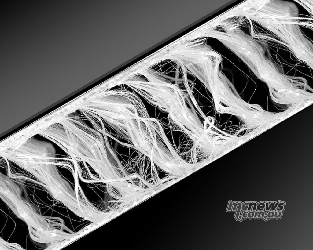 Close-up cutaway showing white internal microfilaments inside a Dainese airbag structure.