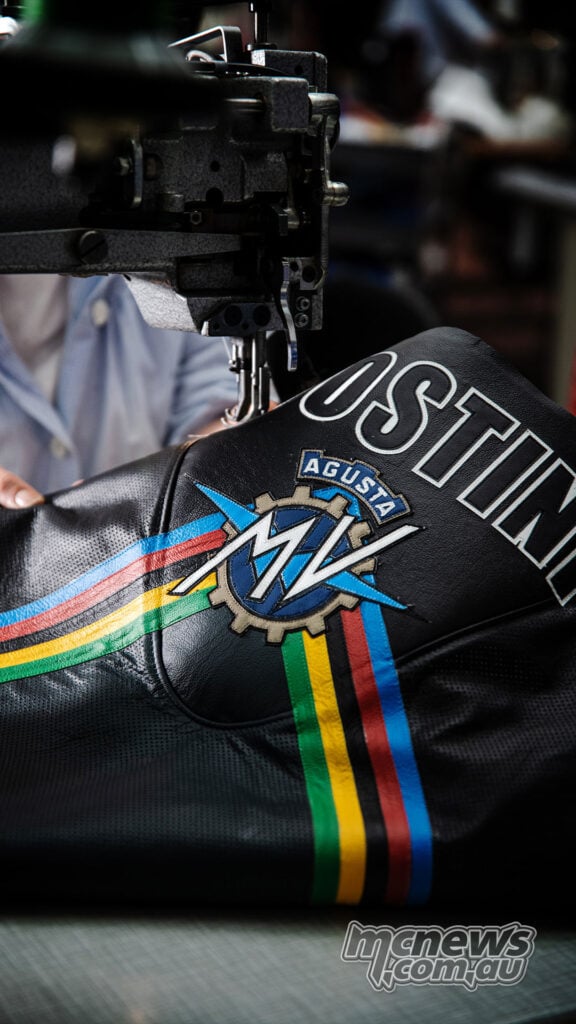Close-up of a black leather Dainese suit panel with MV Agusta branding being sewn.