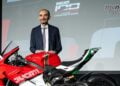 Claudio Domenicali stands beside Ducati Superleggera V4 Centenario Tricolore on stage.