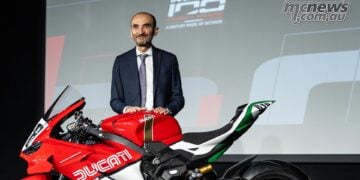 Claudio Domenicali stands beside Ducati Superleggera V4 Centenario Tricolore on stage.