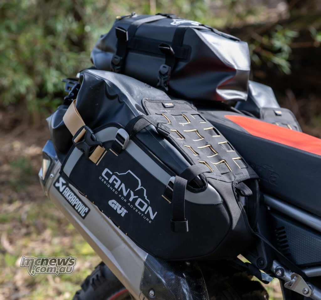 Black Givi Canyon 16-litre side bag mounted low beside the rear wheel of an Aprilia Tuareg 660.