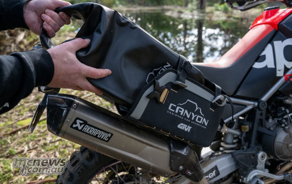 Close-up of the textured material and branding on a black Givi Canyon motorcycle luggage bag.
