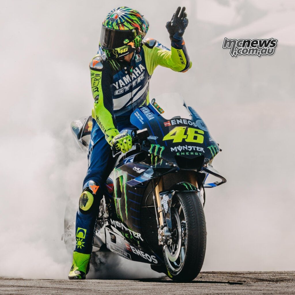 Valentino Rossi waving from his number 46 Yamaha YZR-M1 during a smoky Goodwood demonstration.